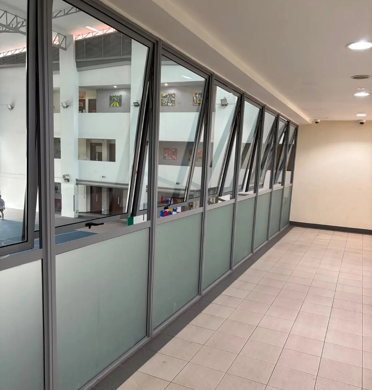 aluminium-casement-windows-corridor Aluminium casement windows installed along an interior corridor overlooking an atrium